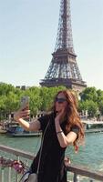Woman taking selfie by Eiffel Tower in Paris video