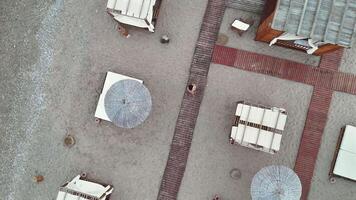 Top view of woman walking on beach boardwalk between cabanas video