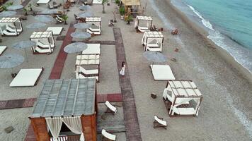Aerial view of woman walking on beach boardwalk by the sea video
