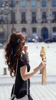 Woman eating baguette while walking at Place Vendome video