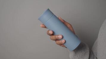 Hand holding a blue thermal flask with a modern design video