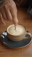 Stirring a cup of coffee with a spoon while in a cafe setting video