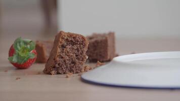 chocolate cake and strawberries dropped on a wooden floor. video