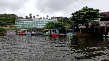 Dunas de Marape Alagoas Brazil June 26 2025 Fishing boats that are anchored along the shore of the Jequia River with the TransAmerican Hotel in the background video