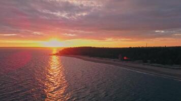 Sunset lights up the calm shore with vivid hues video
