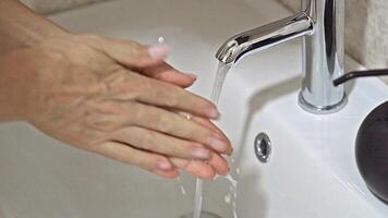 Cleansing Hands Under a Gentle Jet of Water at a Stylish Sink video