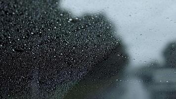 Raindrops on window during urban car ride video