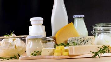 Assorted dairy items arranged neatly on a table black background video
