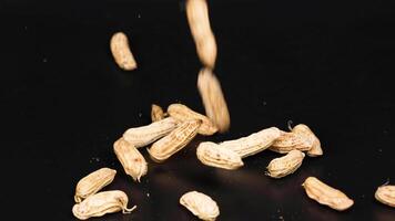 Peanuts dropping and scattering on a black background video