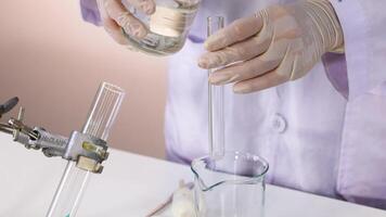 Scientist conducts reaction with sulfuric acid video