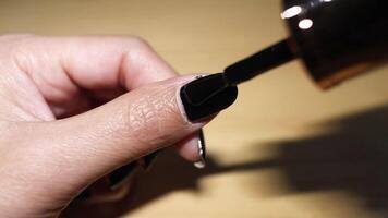 Sequence of applying black nail polish on fingernail video