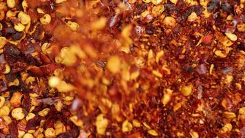 Close-up of vibrant chili flakes cascading, highlighting texture and color in a dynamic macro shot video