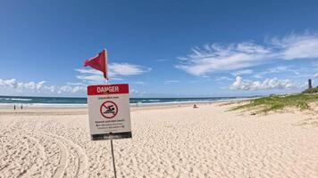 Warning sign on beach with red flag video