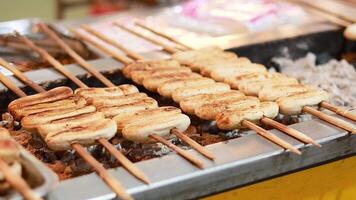 Bananas grilling on skewers at a bustling market video