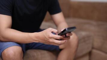 Man sit on sofa and using smart phone in the room video