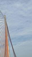 Vietnam Danang 02.07.2025 Experience breathtaking aerial perspective suspension bridge bustling with traffic and cyclists. The bright orange cables contrast beautifully with the urban landscape below. video