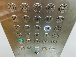 This image provides a detailed closeup view of elevator buttons, specifically highlighting the sleek and shiny silver button that grants access to the highly soughtafter 21st floor photo