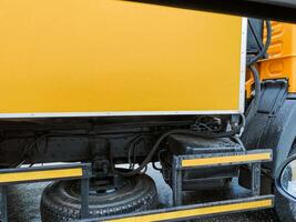 This is an intricate closeup view that showcases the essential components of a yellow trucks underbody and suspension system, highlighting the intricate engineering involved in its design photo