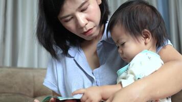 mother reads a storybook to her baby, a mom teaches her child to read, encouraging early learning and bonding through warmth, love, and meaningful interaction video