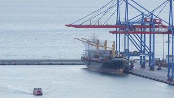 Malaga, Spain, 2019 - Harbor cranes loading merchant containers on a cargo ship before sailing video