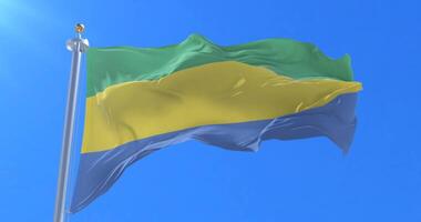 Flag of Gabon waving at wind with blue sky in slow, loop video