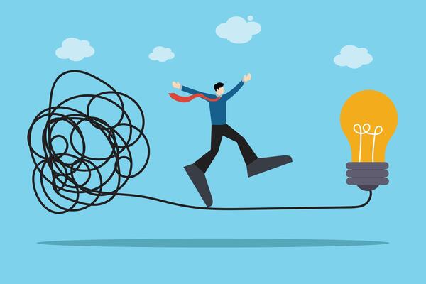 businessman walks a tightrope under pressure, searching for a solution represented by a glowing light bulb. Reflects decision-making in uncertain business conditions.