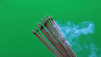 incense and smoke, burning incense with soft smoke rising on green background, representing peace, spirituality, meditation, and eastern culture. video