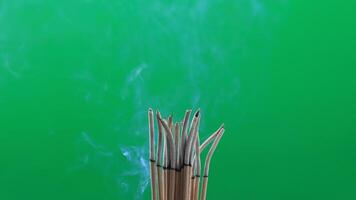 incense and smoke. burning incense with soft smoke rising on green background, representing peace, spirituality, meditation video