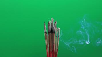 incense and smoke, burning incense with soft smoke rising on green background, representing peace, spirituality, meditation, and eastern culture video