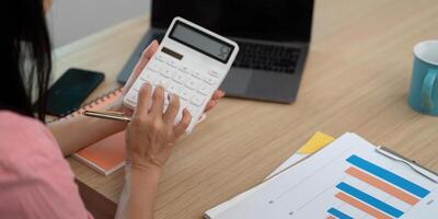 Working from Home. Woman calculating finances with a calculator photo