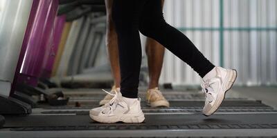 Trainer supporting clients during treadmill exercise session photo