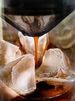 a coffee maker pouring ice into a glass photo