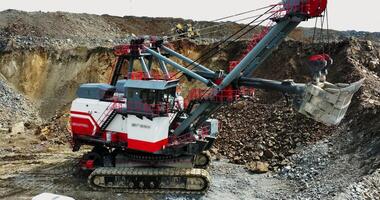 Large excavator mining ore in open pit quarry. Stock clip video
