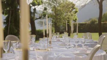An Elegant Outdoor Dining Setup Featuring Beautiful Candles and Exquisite Fine Glassware. Action video