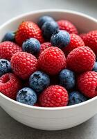 A fresh bowl of mixed berries with raspberries, blueberries, and strawberries photo