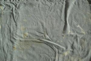 Texture of an old dirty ragged cloth with brown stains. Dirty fabric photo
