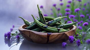 Okra Vegetable in Wood Bowl with Purple Flowers and Dark Drizzle photo