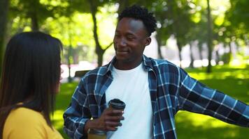 A young African American couple is having a joyful moment in the park. They are smiling and engaging in conversation while cycling, surrounded by lush greenery and warm sunlight. video