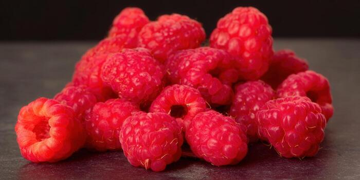 A lush pile of fresh, ripe raspberries, bursting with vibrant red color and deliciousness. photo