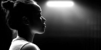 A striking black and white profile portrait of a woman under dramatic lighting. photo