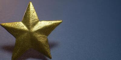 Close-up shot of a golden star against a deep blue backdrop, perfect for awards. photo