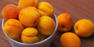 A vibrant image of fresh apricots in a bowl, perfect for a summer treat. photo