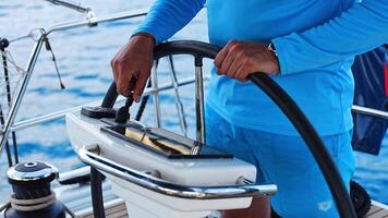 Man steering a sailing yacht using navigation display and control panel near Croatia. Precision, control and modern sailing lifestyle at sea. High quality 4k footage video