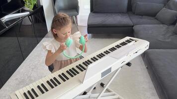 Little girl practicing piano with wireless headphones at home. Early childhood development through modern and focused music education. High quality 4k footage video