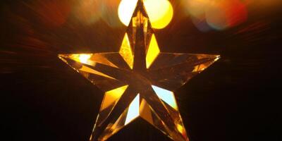 A golden crystal star shines brilliantly against a dark, bokeh-filled background. photo