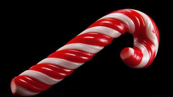 Festive red and white candy cane against a black background. photo