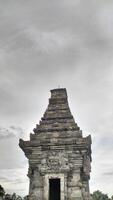 Ancient Stone Temple Against Cloudy Sky, Architectural Detail, Vertical Composition. photo