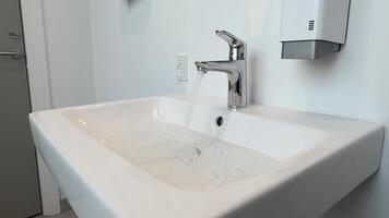 Water flowing from the faucet in the bathroom. Clogged sink. FullHD footage video