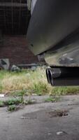 Vertical for a car muffler during engine startup, capturing subtle vibrations and initial exhaust emissions video