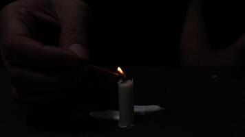 Candlelight Flames Ignited with Matchstick in Dark and a Hand Protects the Burning Candle from the Blowing Wind video